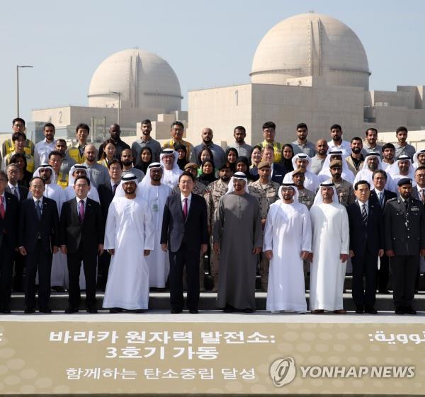 President Yoon Suk Yeol (4th from L, front) and UAE President Mohamed bin Zayed Al Nahyan (5th from L, front) pose for a group photo with officials from both countries during a ceremony marking the commencement of operations of Unit 3 at the Barakah nuclear power plant in Abu Dhabi on Jan. 16, 2023. (Yonhap)