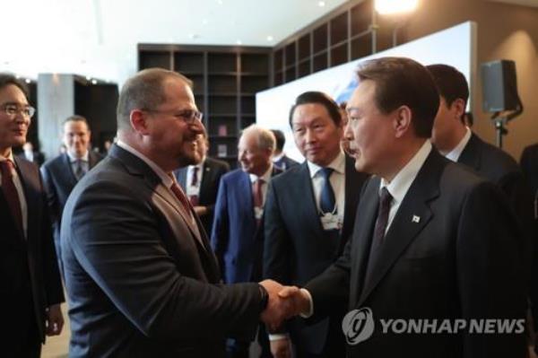 President Yoon Suk Yeol (R) shakes hands with Cristiano Amon, chief executive officer of U.S. chip giant Qualcomm Technologies Inc., during a luncheon with a group of CEOs from South Korean co<em></em>nglomerates and other leading multinatio<em></em>nal companies in Davos, Switzerland, on Jan. 18, 2023. At the center is SK Group Chairman Chey Tae-won. (Yonhap) 