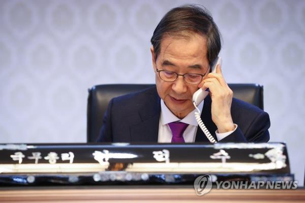South Korean Prime Minister Han Duck-soo talks with his Ukrainian counterpart, Denys Shmyhal, over the phone at Government Complex Seoul on Dec. 23, 2022, in this photo provided by Han's office. (PHOTO NOT FOR SALE) (Yonhap)