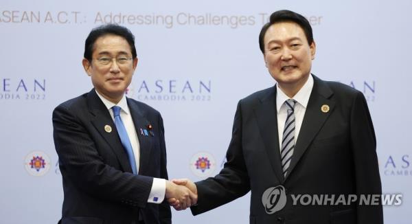 This photo, taken on Nov. 13, 2022, shows President Yoon Suk Yeol (R) shaking hands with Japanese Prime Minister Fumio Kishida prior to their talks on the margins of regio<em></em>nal gatherings in Cambodia. (Yonhap)