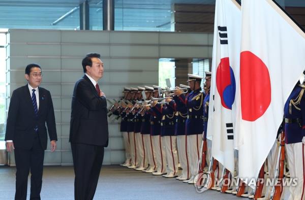 South Korean President Yoon Suk Yeol (R) salutes the natio<em></em>nal flag during an ho<em></em>nor guard inspection prior to summit talks with Japanese Prime Minister Fumio Kishida at the latter's residence in Tokyo on March 16, 2023. Yoon began a two-day trip to Japan to put strained relations back on track. (Yonhap)