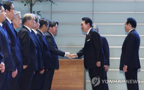 South Korean President Yoon Suk Yeol (2nd from R) shakes hands with Japanese Cabinet members after an ho<em></em>nor guard inspection prior to his summit talks with Japanese Prime Minister Fumio Kishida (R) at the latter's residence in Tokyo on March 16, 2023. Earlier in the day, Yoon began a two-day trip to Japan to put strained relations back on track. (Yonhap)