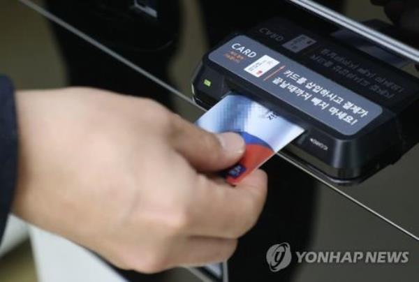 This undated file photo shows a person using an ATM. (Yonhap) 