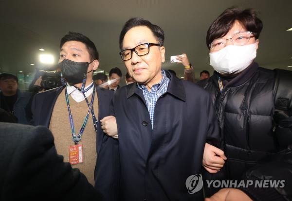 Prosecution officials arrest Cho Hyun-chun (C), a former head of the now-defunct Defense Security Command, at Incheon Internatio<em></em>nal Airport, west of Seoul, on March 29, 2023. (Yonhap) 