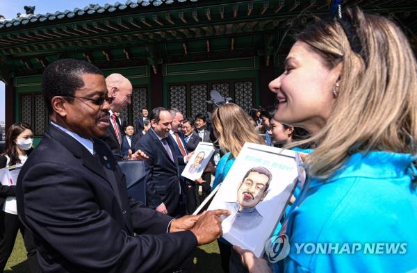 A Bureau Internatio<em></em>nal des Expositions official receives a caricature from a Busan Expo supporter during an event in Seoul on April 3, 2023. (Pool photo) (Yonhap) 