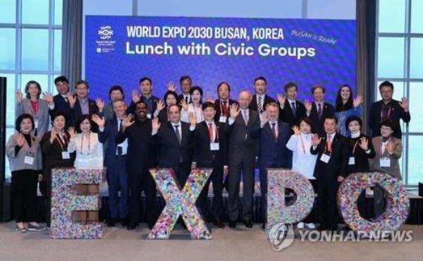 Delegates of the Bureau Internatio<em></em>nal des Expositions and representatives of Busan civic groups pose for a photo in the southeastern South Korean port city on April 5, 2023, in front of plastic co<em></em>ntainers holding 120,000 paper cranes, in this photo provided by the Bid Committee for World Expo 2030 Busan. (PHOTO NOT FOR SALE) (Yonhap)