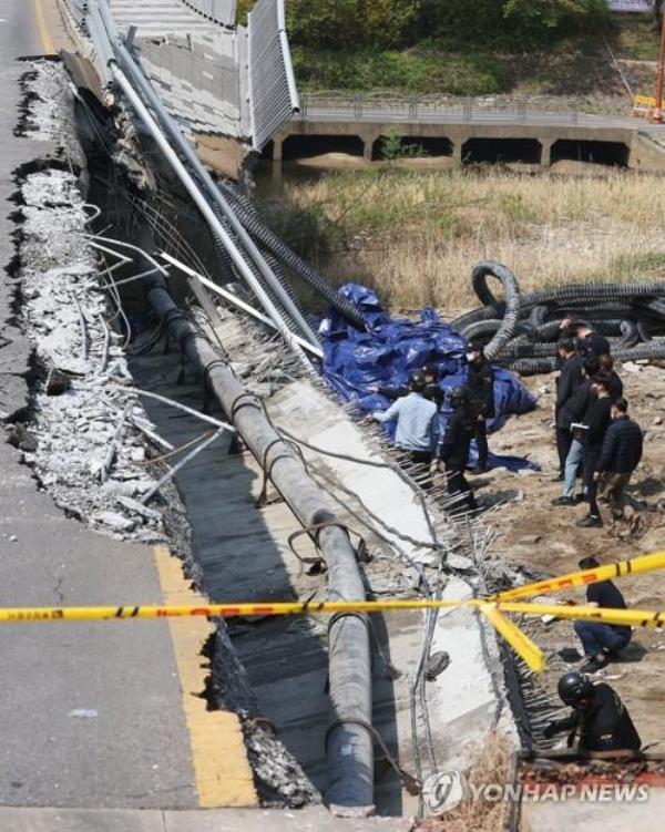 Police investigators examine the site of a collapsed sidewalk on Jeo<em></em>ngja Bridge over a stream in Seongnam, south of Seoul, on April 7, 2023. (Yonhap)