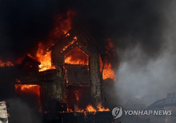 A guesthouse in Gangneung, 168 kilometers east of Seoul, is on fire, as a wildfire spreads across Gangwon Province on April 11, 2023. (Yonhap)