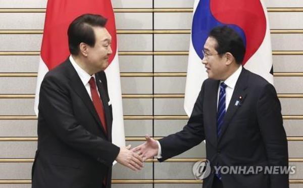 South Korean President Yoon Suk Yeol (L) and Japanese Prime Minister Fumio Kishida shake hands prior to their expanded summit talks at the latter's residence in Tokyo on March 16, 2023. Earlier in the day, Yoon began a two-day trip to Japan to put strained relations back on track. The summit marks the first time in 12 years that such talks have taken place amid tense relations between the two nations. (Yonhap)