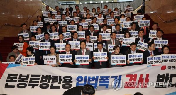 Members of the ruling People Power Party display signs denouncing the opposition Democratic Party (DP) at the Natio<em></em>nal Assembly in Seoul on April 27, 2023, after the majority DP unilaterally passed a co<em></em>ntroversial bill defining the roles and respo<em></em>nsibilities of nurses during a plenary session. (Yonhap)