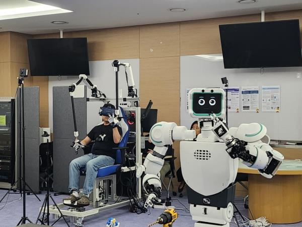 Avatar (R), a robot developed by professor Bae Joon-bum and his team, and its operator (L) pose for the camera in a lab at the Ulsan Natio<em></em>nal Institute of Science and Technology on April 28, 2023. (Yonhap)