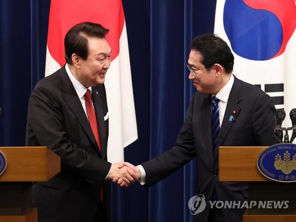 In this file photo, President Yoon Suk Yeol (L) shakes hands with Japanese Prime Minister Fumio Kishida at the end of their joint news co<em></em>nference after their summit in Tokyo on March 16, 2023. (Yonhap)