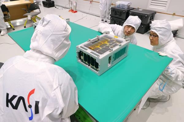 This undated photo provided by the Korea Aerospace Research Institute (KARI) shows officials inspecting a microsatellite developed by the Korea Astro<em></em>nomy and Space Science Institute, codenamed SNIPE, at the Naro Space Center in Goheung, South Jeolla Province. (PHOTO NOT FOR SALE) (Yonhap)
