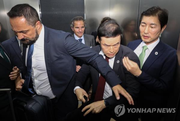 Rafael Mariano Grossi (1st in the back row), director general of the Internatio<em></em>nal Atomic Energy Agency, moves to another location to avoid protesters after arriving at Gimpo Internatio<em></em>nal Airport in western Seoul on July 7, 2023. (Pool photo) (Yonhap)