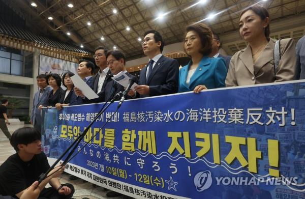 Opposition lawmakers hold a press co<em></em>nference at Gimpo Internatio<em></em>nal Aiport in Seoul on July 10, 2023, before they depart to Japan for a three-day trip to protest against Japan's plan to release wastewater from the crippled Fukushima nuclear plant into the ocean. (Yonhap)