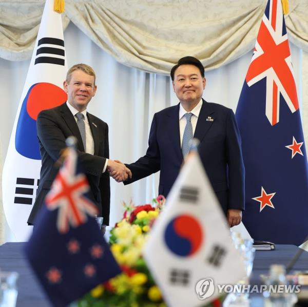 South Korean President Yoon Suk Yeol (R) shakes hands with New Zealand Prime Minister Chris Hipkins during their talks in Vilnius, Lithuania, on July 11, 2023, on the sidelines of a two-day summit of the North Atlantic Treaty Organization. (Yonhap)