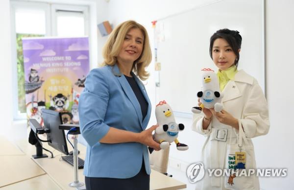 Kim Keon Hee (R), wife of South Korean President Yoon Suk Yeol, and Inga Zaleniene, rector of Mykolas Romeris University, pose for a photo with Boogi, the seagull-themed mascot of South Korea's largest port city of Busan, as she visits the King Sejong Institute at the university in Vilnius, Lithuania, on July 11, 2023. Kim was accompanying Yoon, who came to the Lithuanian capital to attend a summit of the North Atlantic Treaty Organization. (Pool photo) (Yonhap)