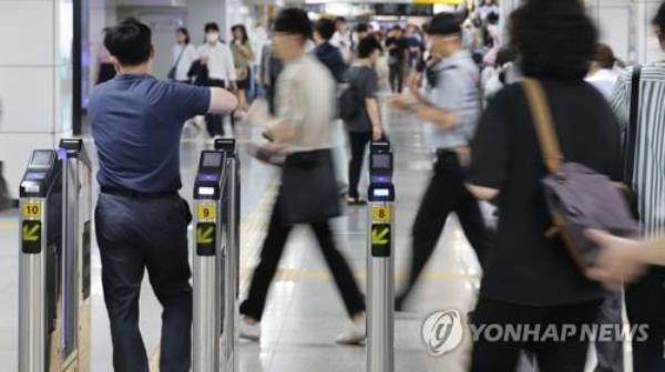Passengers pass through ticket gates at a subway station in Seoul on July 12, 2023. (Yonhap)