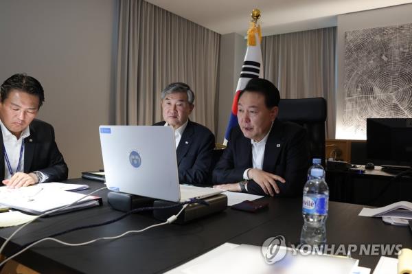 South Korean President Yoon Suk Yeol (R) presides over an emergency Natio<em></em>nal Security Council meeting via video in Vilnius, Lithuania, on July 12, 2023, in this photo provided by his office. (PHOTO NOT FOR SALE) (Yonhap)