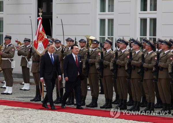 South Korean President Yoon Suk Yeol (R), accompanied by Polish President Andrzej Duda, inspects an ho<em></em>nor guard during a welcome ceremony for Yoon at the presidential palace in Warsaw on July 13, 2023. (Yonhap)