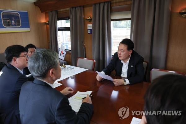 President Yoon Suk Yeol (facing camera) holds a meeting with his aides on the government's respo<em></em>nse to heavy rains in South Korea on July 15, 2023, in this photo provided by the presidential office. (PHOTO NOT FOR SALE) (Yonhap)