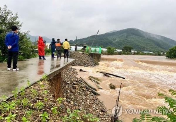 Officials inspect the site of a collapsed embankment near a stream in the aftermath of heavy rains in the central county of Cheo<em></em>ngyang on July 15, 2023. (Yonhap)