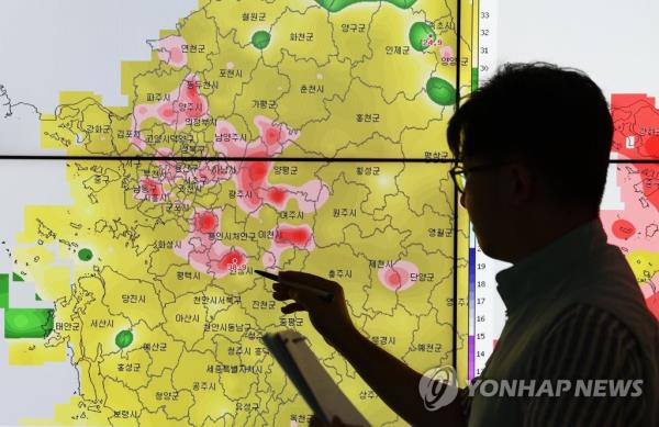 A weather forecaster looks at a map of natio<em></em>nwide temperatures at a state weather agency office in Suwon, south of Seoul, on July 30, 2031. (Yonhap)