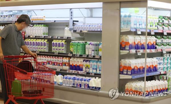 A shopper selects groceries at a supermarket in Seoul on July 27, 2023. (Yonhap)