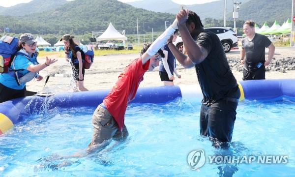 Participants at the World Scout Jamboree in the Saemangeum reclamation area on South Korea's southwest coast play in an outdoor pool on Aug. 6, 2023. (Yonhap)