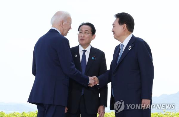 South Korean President Yoon Suk Yeol (R) speaks with U.S. President Joe Biden (L) and Japanese Prime Minister Fumio Kishida ahead of their three-way talks in Hiroshima, Japan, on May 21, 2023. (Pool photo) (Yonhap)