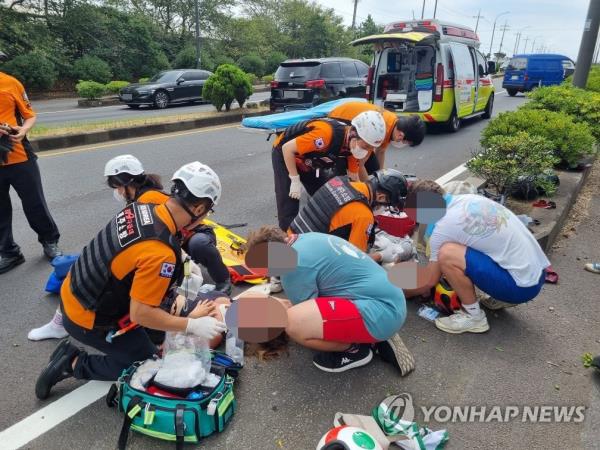 This photo, provided by Jeju Fire Safety Headquarters, shows two Scouts from Germany being transferred to a nearby hospital after their motorcycle crashed o<em></em>nto curbsto<em></em>nes in Jeju's Seogwipo region on Aug. 17, 2023. (PHOTO NOT FOR SALE) (Yonhap)