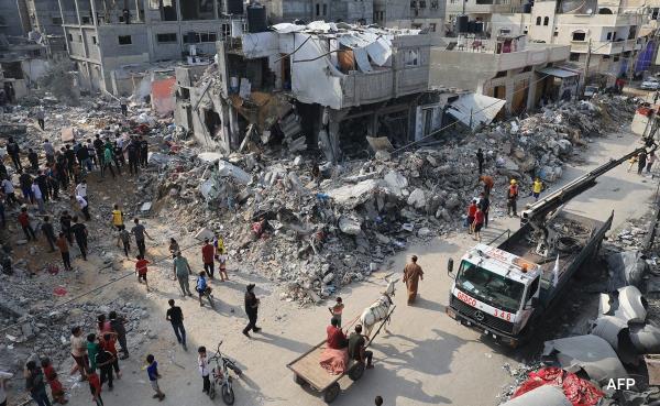 People walk around ruins of building destroyed in Israeli airstrikes in Gaza after Hamas surprise attack