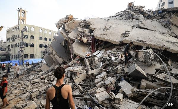 A Palestinian man stands in front of the rubble of Gaza Citys Al-Watan Tower, which was destroyed in Israeli airstrike