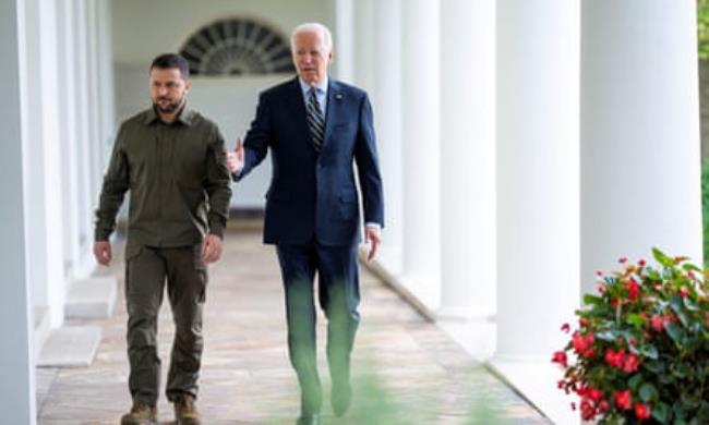 Volodymyr Zelenskiy and Joe Biden walking along the colo<em></em>nnade at the White House