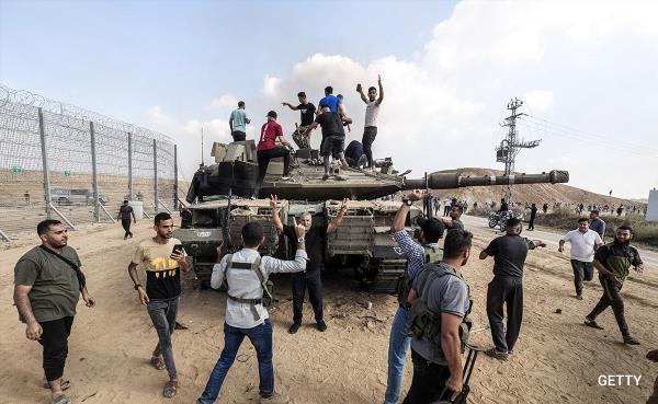 The Hamas group after taking co<em></em>ntrol of an Israeli tank after crossing the border fence with Israel from Khan Yunis.