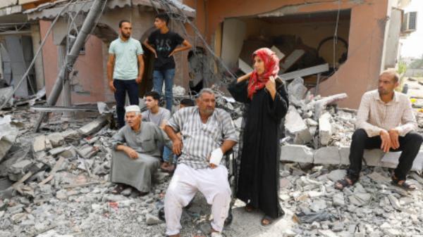 Palestinians watch the civil defense team as they search for victims trapped under the rubble of a house destroyed during Israeli strikes, in Khan Younis, in the southern Gaza Strip, October 8, 2023. REUTERS/Ibraheem Abu Mustafa
