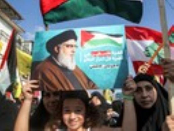 A girl holds up a sign showing Hassan Nasrallah, the leader of Lebanese Shiite movement Hezbollah on Oct. 8.